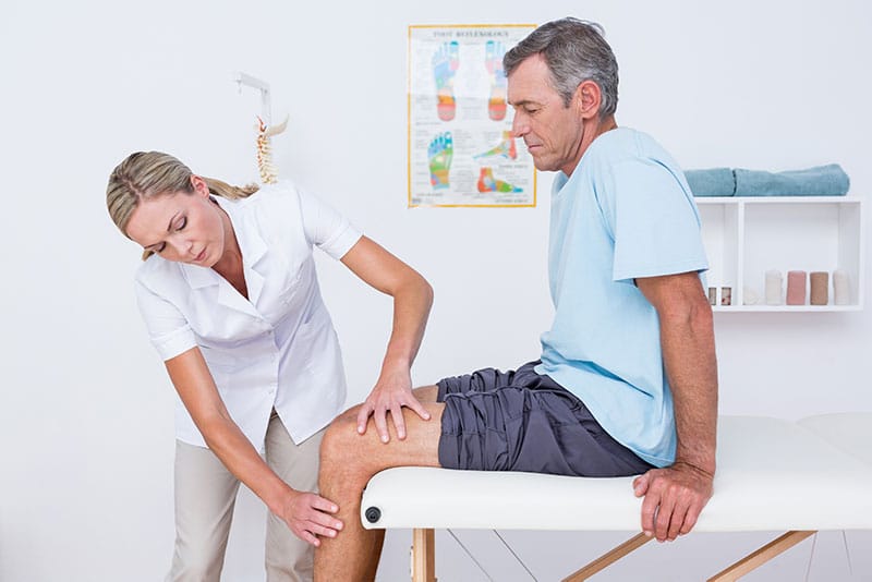 doctor evaluates patients knee